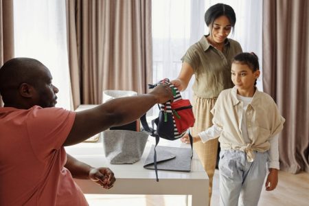 parents-helping-their-daughter-to-get-ready-for-school-4261256